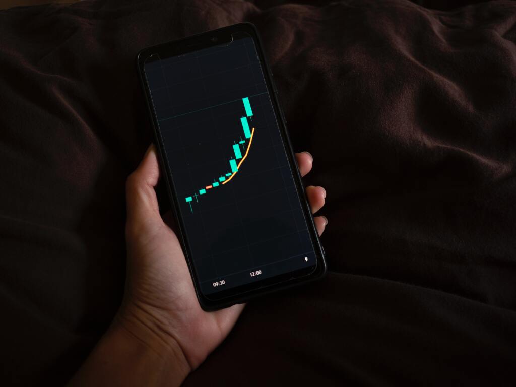 Phone in a hand with trending chart